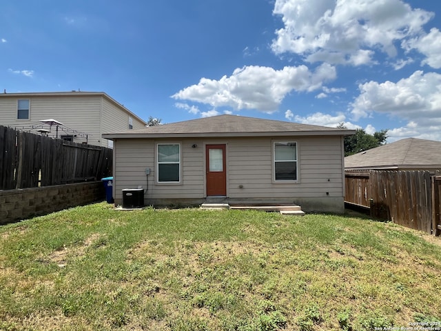 rear view of property with a yard and central AC unit