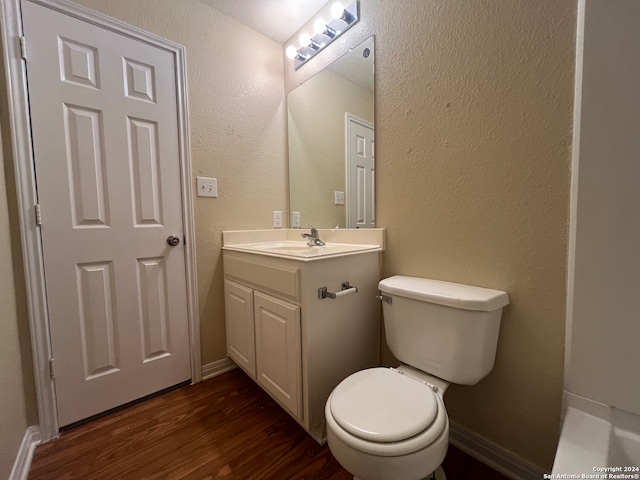 bathroom featuring toilet, vanity, and hardwood / wood-style floors