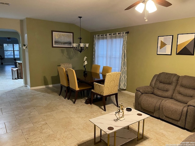 living room featuring ceiling fan with notable chandelier and vaulted ceiling