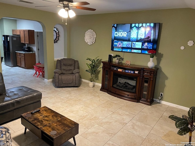 tiled living room with ceiling fan