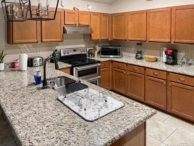 kitchen with light stone countertops, an inviting chandelier, stainless steel appliances, and sink