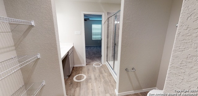 bathroom featuring an enclosed shower, hardwood / wood-style flooring, and vanity