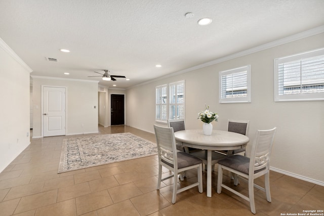 dining room with light tile patterned floors, ornamental molding, ceiling fan, and a wealth of natural light