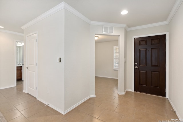 foyer featuring ornamental molding and light tile patterned floors