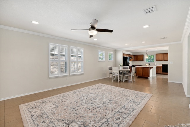 tiled living room featuring ceiling fan and ornamental molding