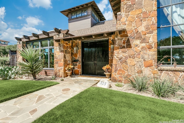 property entrance featuring a lawn