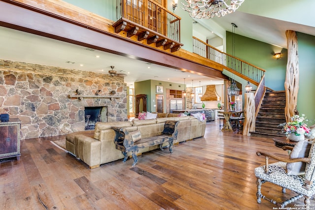 living room featuring a high ceiling, wood-type flooring, and a fireplace