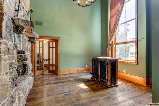 interior space featuring wood-type flooring, a stone fireplace, and french doors