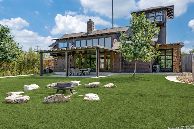 back of house featuring a lawn, a pergola, a patio, an outdoor fire pit, and ceiling fan