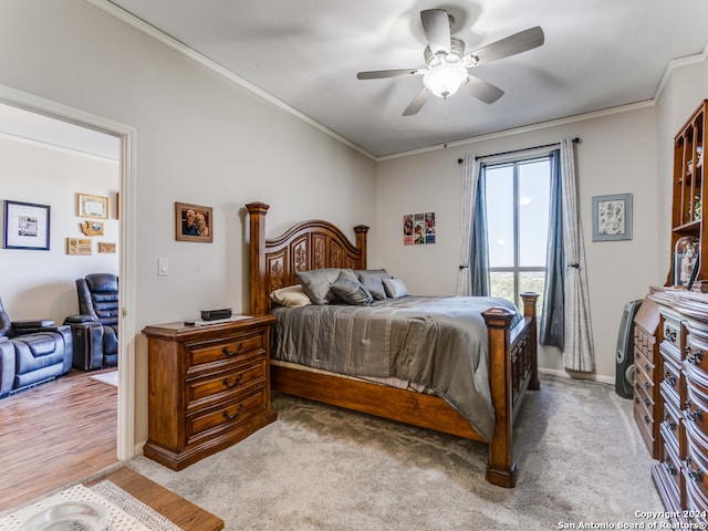 carpeted bedroom with ceiling fan and ornamental molding