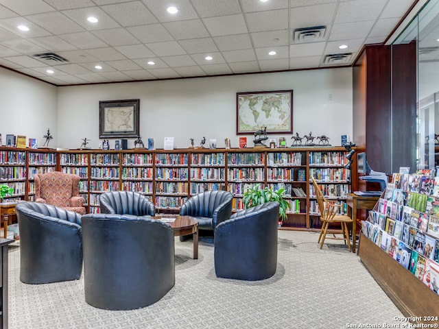 sitting room with a drop ceiling and carpet flooring