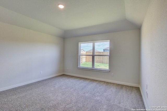 unfurnished room featuring carpet floors and lofted ceiling