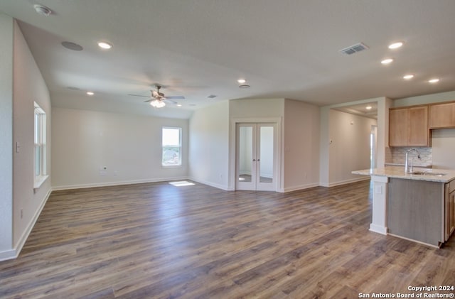 unfurnished living room featuring ceiling fan, dark hardwood / wood-style floors, and sink