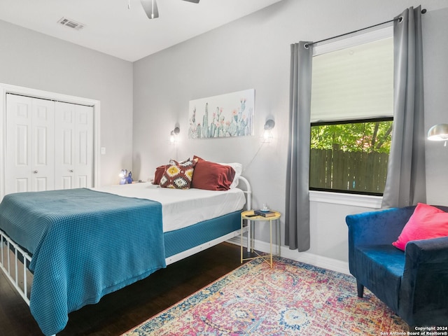 bedroom with ceiling fan, a closet, and dark wood-type flooring