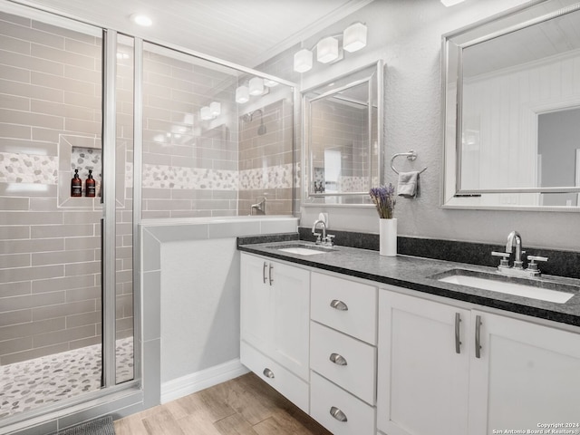 bathroom featuring crown molding, hardwood / wood-style floors, a shower with shower door, and vanity