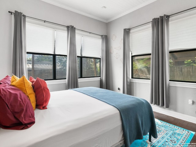 bedroom featuring multiple windows, crown molding, and hardwood / wood-style floors