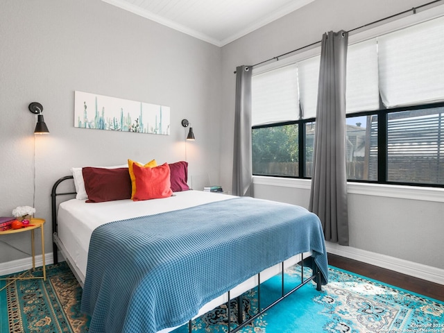 bedroom with ornamental molding and dark wood-type flooring