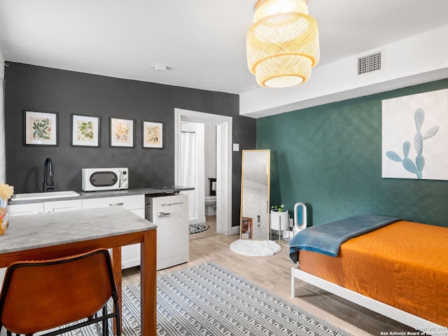 bedroom featuring sink and light wood-type flooring