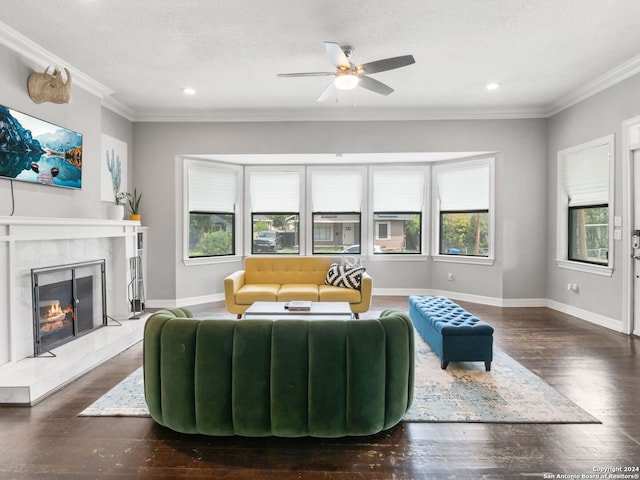 living room with ornamental molding, plenty of natural light, a tile fireplace, and dark hardwood / wood-style floors