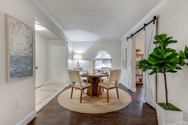 dining area with crown molding and a barn door