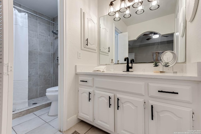 bathroom featuring tile patterned floors, vanity, toilet, ceiling fan, and tiled shower