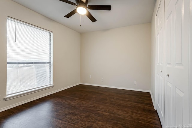 spare room with dark wood-type flooring and ceiling fan