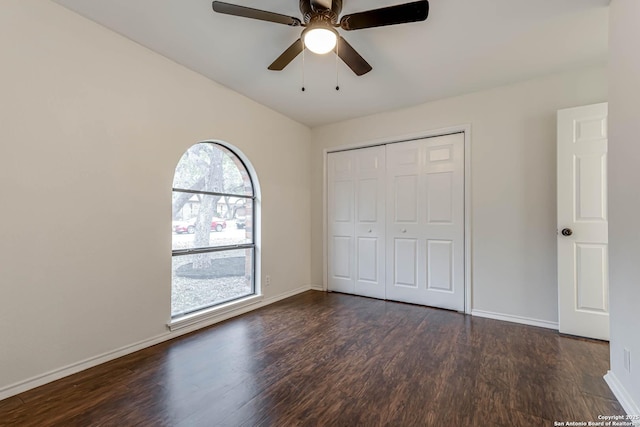 unfurnished bedroom with a closet, ceiling fan, and dark wood-type flooring