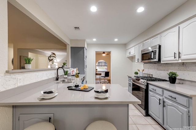 kitchen featuring kitchen peninsula, appliances with stainless steel finishes, and a breakfast bar