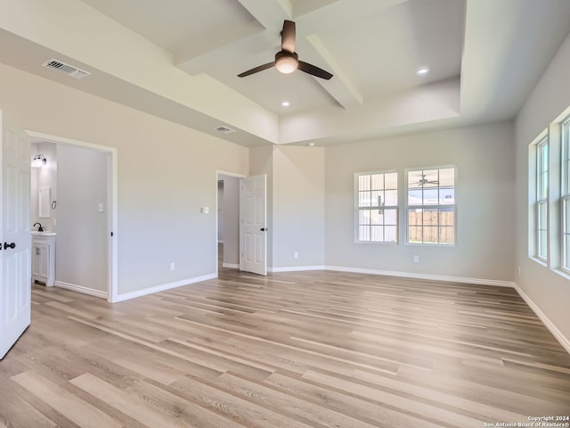 empty room with beamed ceiling, ceiling fan, and light hardwood / wood-style flooring