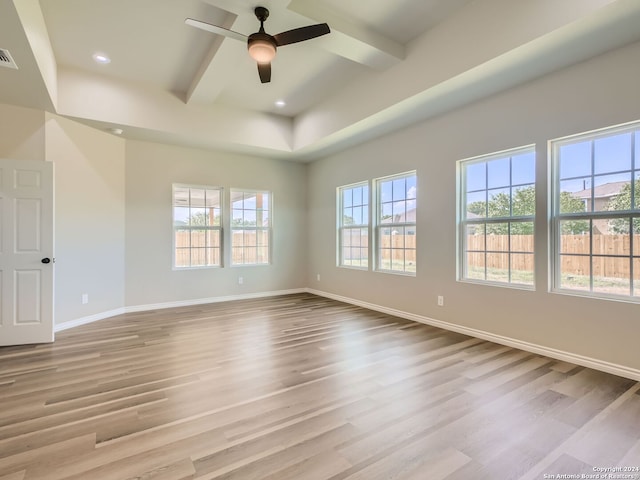 unfurnished room featuring light hardwood / wood-style floors, ceiling fan, and beamed ceiling