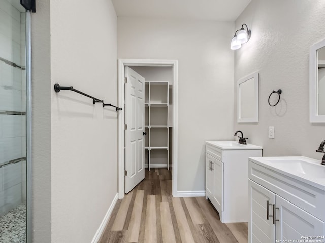 bathroom featuring hardwood / wood-style floors, a shower with shower door, and vanity