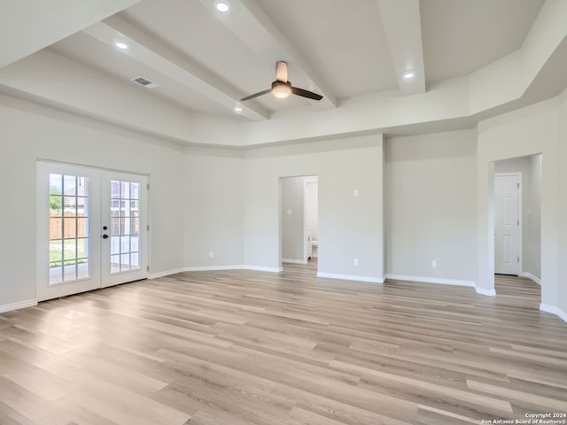 spare room with ceiling fan, light hardwood / wood-style flooring, a towering ceiling, and french doors