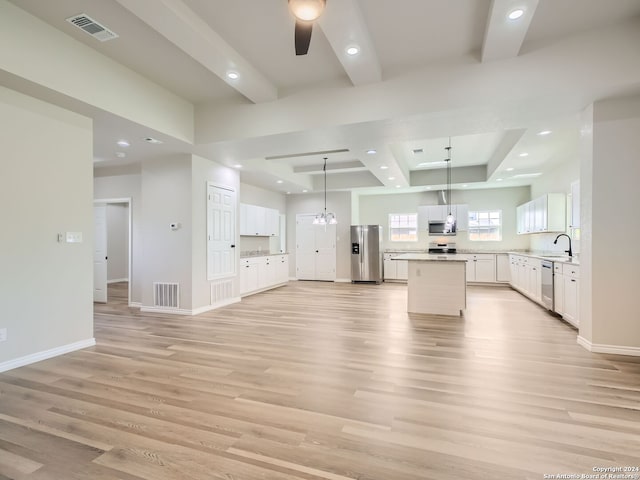 kitchen with appliances with stainless steel finishes, light hardwood / wood-style floors, a kitchen island, and white cabinetry