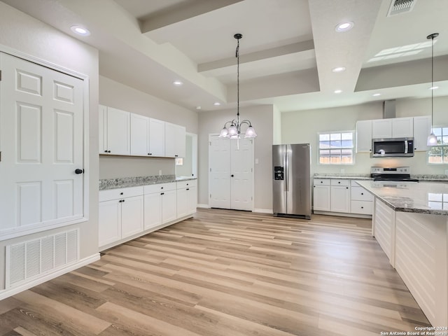 kitchen with light wood-type flooring, hanging light fixtures, white cabinetry, appliances with stainless steel finishes, and light stone countertops