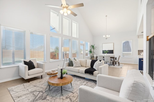 tiled living room featuring ceiling fan with notable chandelier and high vaulted ceiling