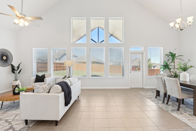 tiled living room featuring ceiling fan with notable chandelier, high vaulted ceiling, and a wealth of natural light