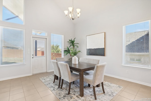 tiled dining room featuring an inviting chandelier, plenty of natural light, and high vaulted ceiling