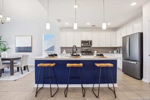 kitchen with sink, hanging light fixtures, white cabinetry, and black appliances