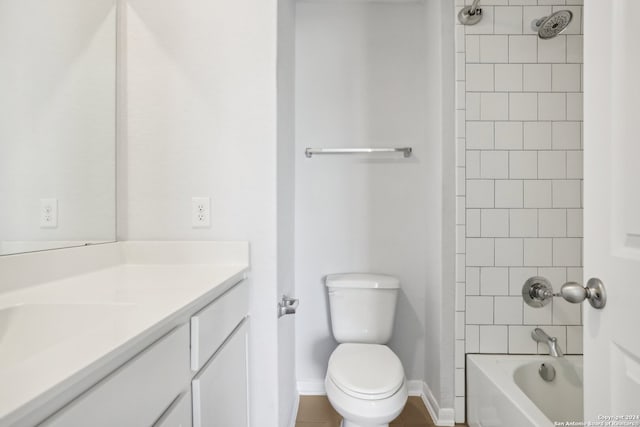 full bathroom with tiled shower / bath, vanity, and toilet