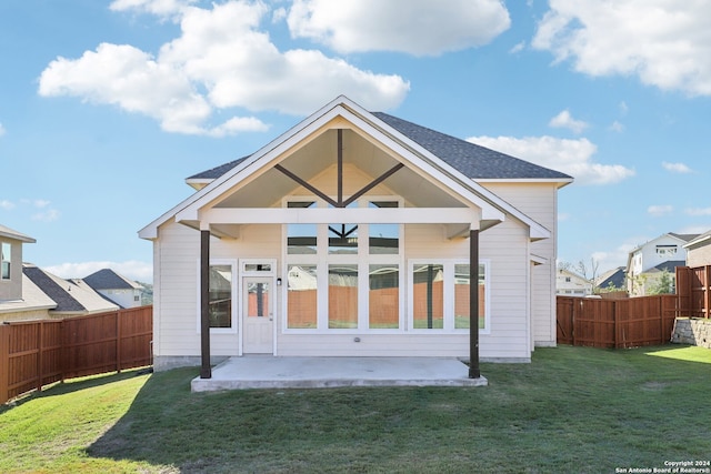 rear view of house featuring a lawn and a patio area