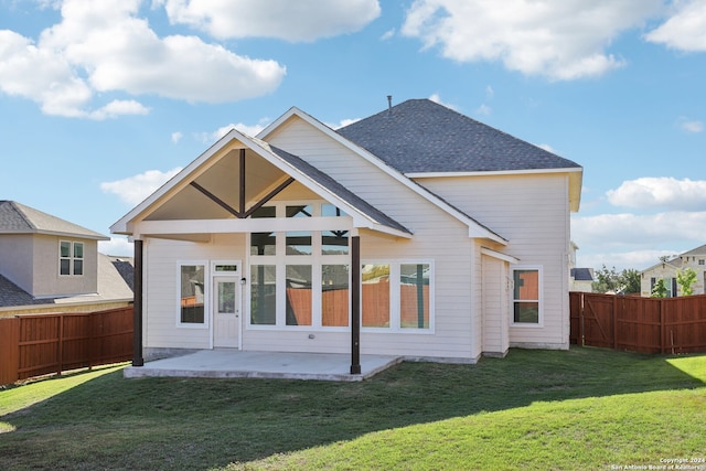 rear view of house featuring a patio and a yard