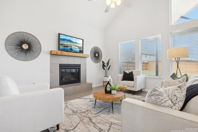 living room featuring high vaulted ceiling, ceiling fan, and a fireplace