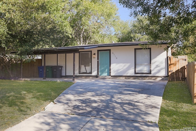 view of front of property with a front lawn and a carport