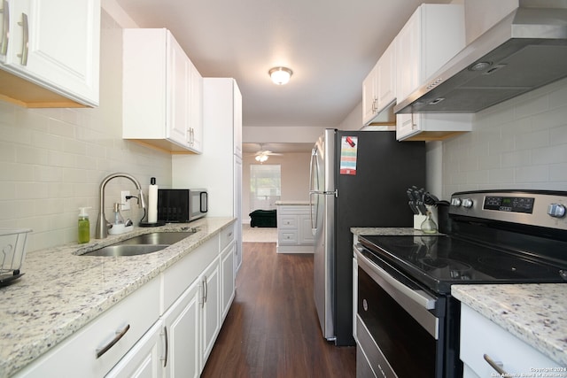 kitchen with appliances with stainless steel finishes, white cabinetry, dark hardwood / wood-style floors, and wall chimney range hood