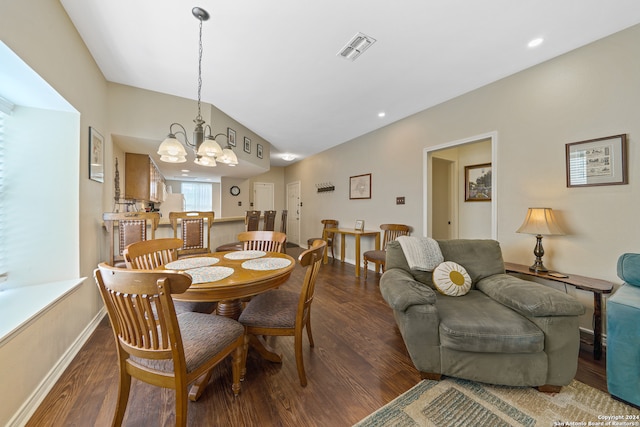 dining space featuring vaulted ceiling, a chandelier, and dark hardwood / wood-style flooring