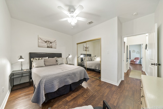 bedroom with a closet, dark hardwood / wood-style floors, and ceiling fan