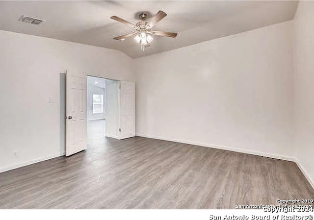 spare room featuring dark wood-type flooring and ceiling fan