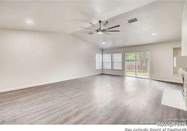 unfurnished living room featuring vaulted ceiling, hardwood / wood-style floors, and ceiling fan