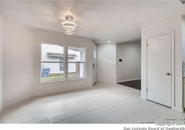 spare room with a notable chandelier