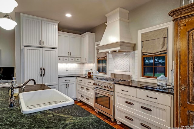 kitchen featuring custom range hood, white cabinetry, premium appliances, dark hardwood / wood-style floors, and sink